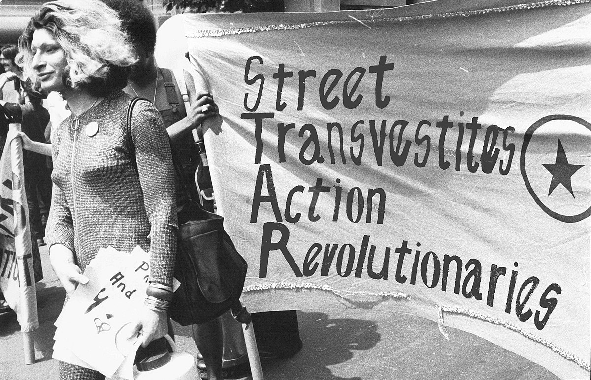 rivera walking in front of a banner that says street transvestites action revolutionaries