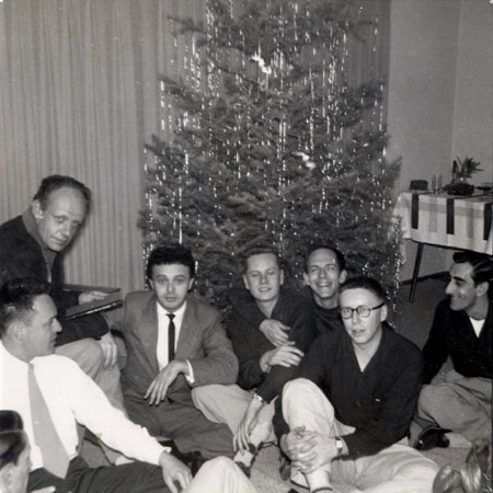 a group of men in front of a christmas tree with lots of tinsel
