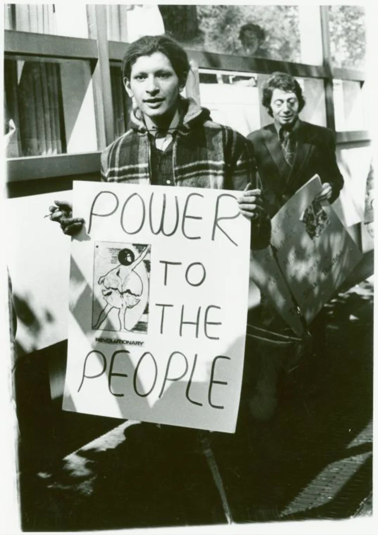 rivera in a black and white photo holding a sign that says power to the people